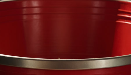Red metal bucket close-up, selective focus. Abstract background.の素材
