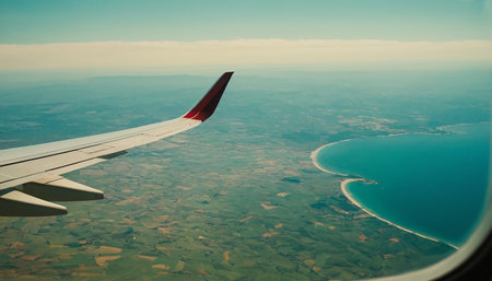 Wing of an airplane flying above the sea. View from the window.の素材