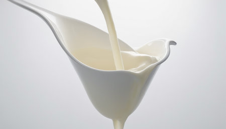 pouring milk into a glass on a white background, closeupの素材