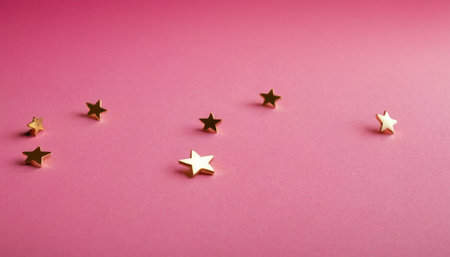 Golden stars on a pink background. Christmas and New Year concept.の素材