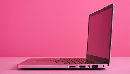 Laptop with pink screen on pink background, close-up.の素材