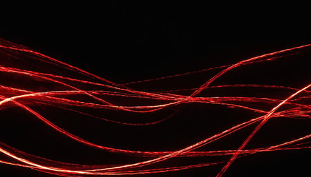 Red wavy lines on a black background. Abstract light background.の素材