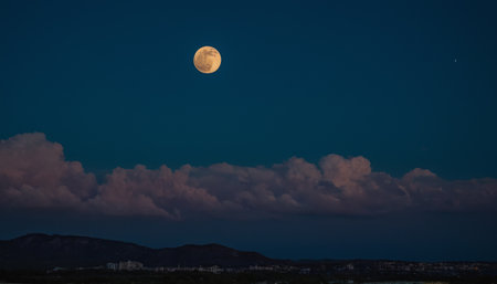 Full moon over the city at night in Sardinia, Italy.の素材