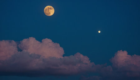 Moon and clouds in the night sky. Beautiful sky with full moon.の素材