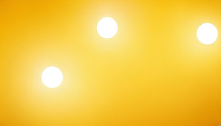 Ceiling lights on yellow background. Yellow background with white bulbs.の素材