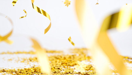 Golden confetti and streamer on white background. Festive conceptの素材