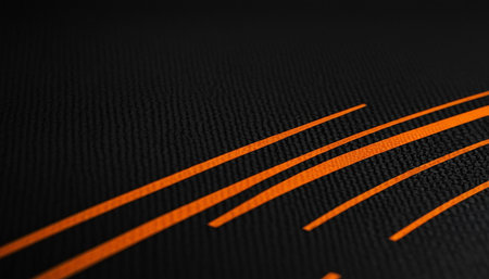 Close-up of a black carbon fiber texture with orange stripes.の素材