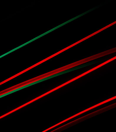 Abstract red and green neon stripes on black background. Long exposure photo.の素材