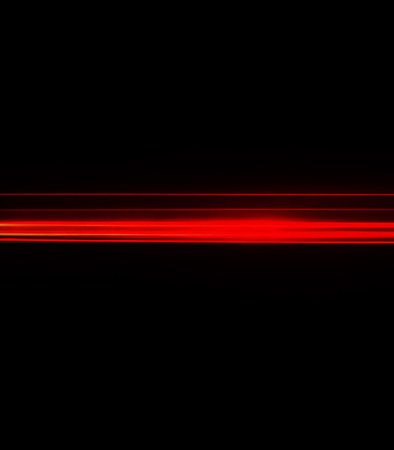 Abstract red light lines on black background. Futuristic technology style.の素材