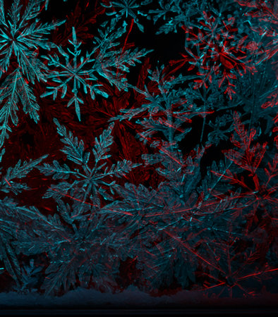 Frosty winter background with snowflakes in blue and red colorsの素材