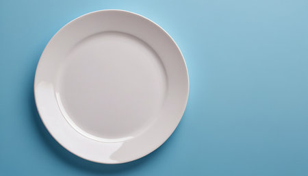 Empty plate on blue background. Top view. Copy space for text.の素材