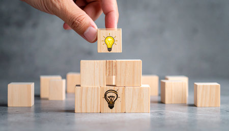 Wooden block stacking as step stair and light bulb icon on top. Business growth concept.の素材