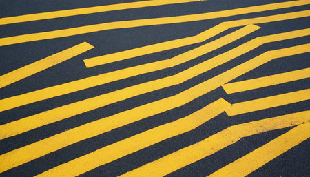 Yellow arrow on the road with black and white stripes, background textureの素材