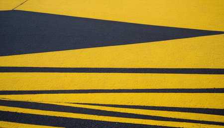 Asphalt road with yellow and black stripes. Abstract background texture.の素材