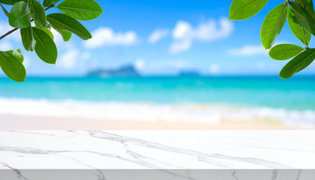 White marble table top with blur tropical beach background - can be used for display or montage your productsの素材