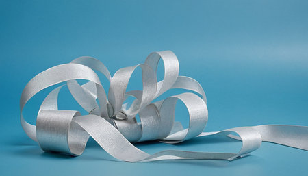 Silver ribbon on a blue background with copy space for your text.の素材