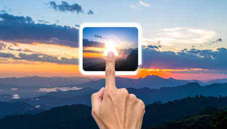 hand touch screen smart phone with sunrise on the mountain at nature backgroundの素材