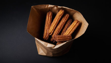 Pecan sticks in a paper bag on a black background.の素材