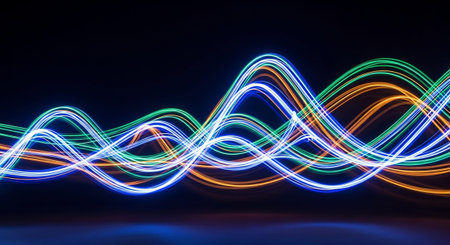 A striking abstract featuring bright neon light trails forming dynamic wave patterns. The colors are a vivid combination of electric blue, emerald green, and fiery orange, accented by white and yellow highlights. These luminous lines flow and intertwine against a dark, possibly reflective surface, creating a sense of depth and energy. The visual evokes concepts of sound waves, digital data, or abstract energy flows. The contrast and vibrancy make it a compelling background orの素材