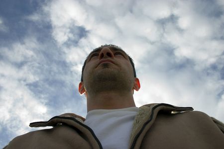 Man Looking up with the Clouds and the Blue Skies on the Background