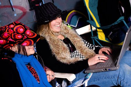 Girls sitting down in a grunge building with grafittis on the wall