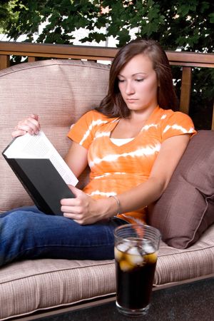 Beautiful Girl Reading a Book in the Patioの写真素材