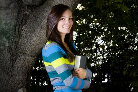 Close up on a Beautiful Teenager with Leaves in the Backgroundの写真素材