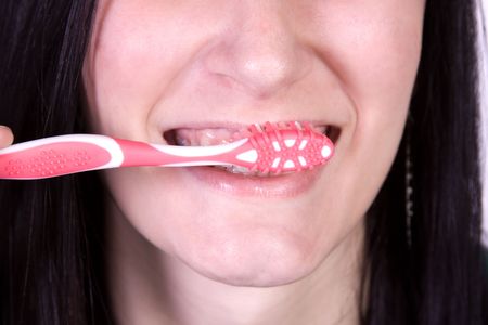 Close up on a beautiful girl brushing her teeth の写真素材