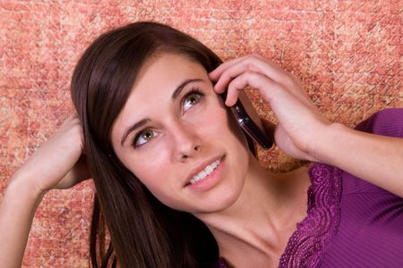 Teenager Talking on the Cell Phone on a Green Couchの写真素材