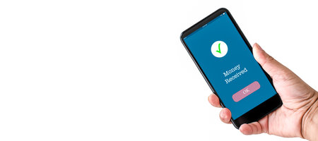 A man's hand holds a smartphone on the screen with the message money received. Concept of financial transactions with mobile devices. Closeup, copy space on left for design or text. White background.の写真素材
