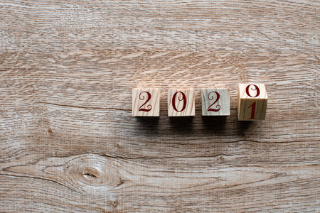 Top view. Wooden cube with word 2020 2021 New Year concept on Wood table background. Closeup and...