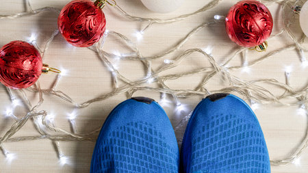Blue Sneakers placed on a wooden table in living room. Concept for the Christmas season, ball red and white, lights, bright, Close up, canvas shoesの写真素材