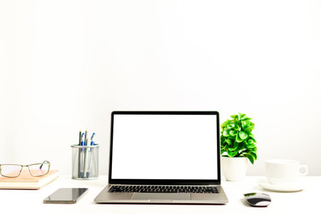 A working concept using technology, notebook, smartphones, devices. Blank white screen laptop on a...