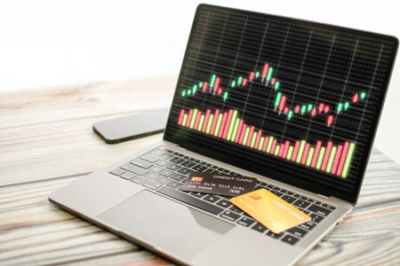 The graph displayed on a laptop screen and a credit card placed on the keyboard. Concept for trading...