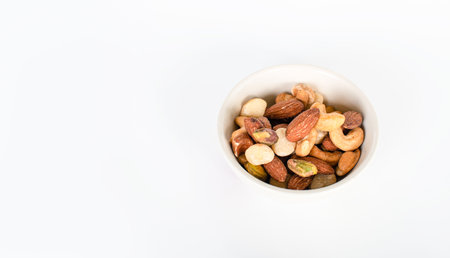 Concept, trail mix day. trail mix In a cup placed on a white floor table. Closeup. copy space on...