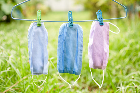 Handmade cloth mask, beautifully colorful, hang in the sun. Mask concept that helps prevent the spread of a coronavirus (COVID-19). Closeup, copy space on right for design or text, Blurred backgroundの写真素材