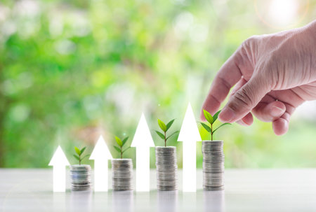 Close up of businessman hand stacking coins with green bokeh background, Business Finance and Money...