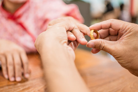 A man wears an engagement ring to propose at a shopping mall which expresses his love happily. The concept for Valentine's Day, Marriage, Engagement, Couple, Married couple. Closeup, blurry backgroundの写真素材