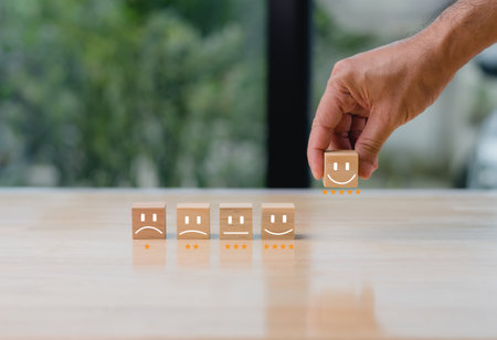 best excellent business services rating customer experience. Satisfaction survey concept. Hand of a businessman holding and chooses a smile face on wooden block cube. 5 Star Satisfaction. Copy spaceの写真素材