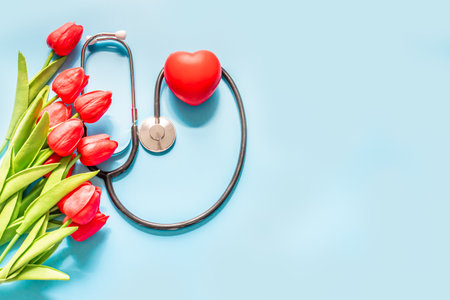 Stethoscope, tulips, on blue background. Greeting background. Happy nurse's day. Health day. National doctor's day. Top view, Closeup, Copy space on right for the design. Thank you, doctors and nurses. Selective focusの写真素材