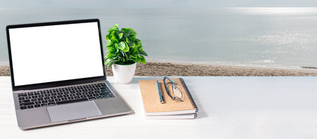Blank and white screen laptop on a wooden table in the office. Working concept using technology,...