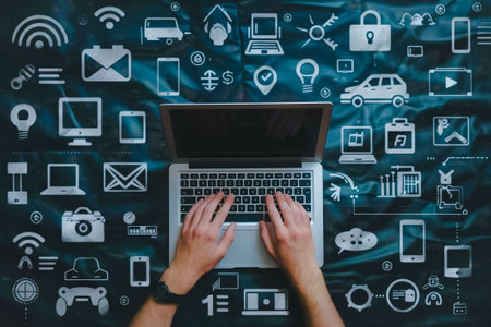 Top view of a person's hands on a laptop with a background full of digital connectivity and technology icons representing the Internet of Things.の素材