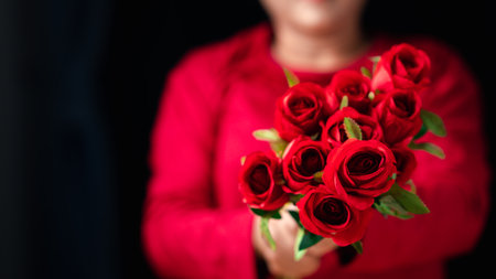 The concept for Valentine's day is on 14th February 2023. Woman holding red rose on Valentine's Day,...