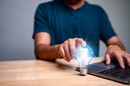 The man touching the lamp tube is a symbolic representation of his imaginative and creative mind, suggesting that he is full of innovative ideas that could lead to business success.の写真素材