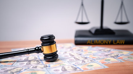 The gavel on a dollar bill in a courtroom represents the complex interplay between alimony law, alimony taxes, financial power, highlighting the need for clear legal frameworks, ethical considerationsの写真素材