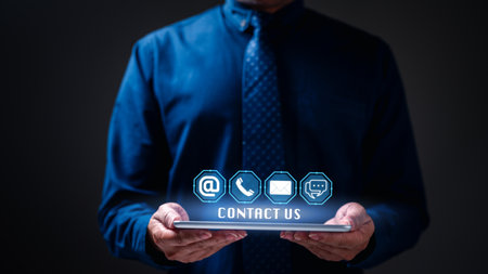 Businessman holding contact us a concept. For personalized service, contact us through phone or electronic mail, message, post, establishing a direct connection for support and feedback.の写真素材