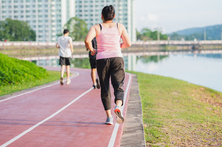 sport, exercise concept. runner woman wearing sports shoes for running, jogging on running track in stadium morning. people exercise of healthy and lifestyle. exercise outdoor in nature park in summerの写真素材