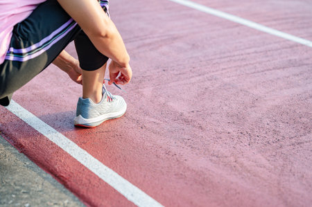 sport, exercise concept. runner woman wearing sports shoes for running, jogging on running track in stadium morning. people exercise of healthy and lifestyle. exercise outdoor in nature park in summerの写真素材