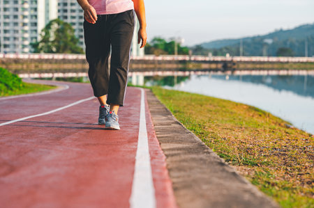 sport, exercise concept. runner woman wearing sports shoes for running, jogging on running track in stadium morning. people exercise of healthy and lifestyle. exercise outdoor in nature park in summerの写真素材