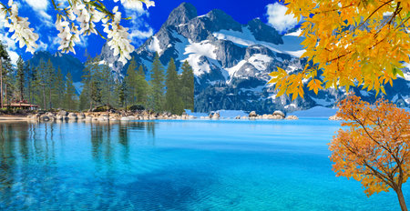 Beautiful autumn landscape with alpine lake and snow-capped mountainsの写真素材